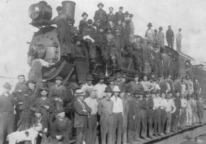 Photo of Men all sitting on a steam engine Photo of Men all sitting on a steam engine